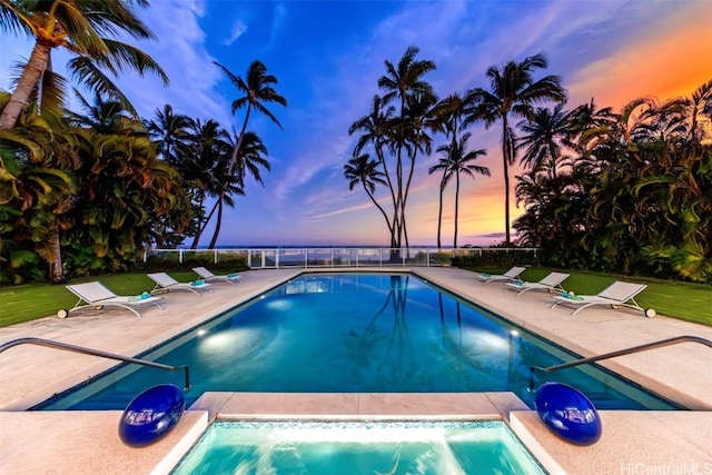 pool at dusk featuring a patio area