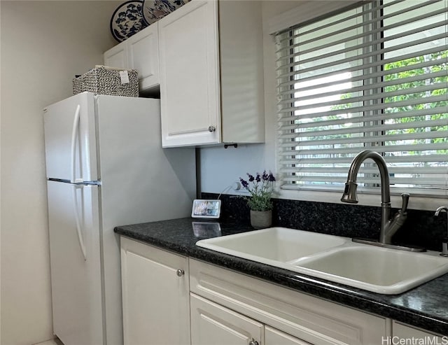 kitchen with a wealth of natural light, sink, white cabinets, and white refrigerator