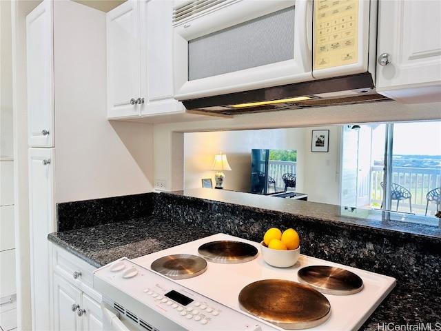 kitchen featuring white cabinets, white appliances, and dark stone countertops