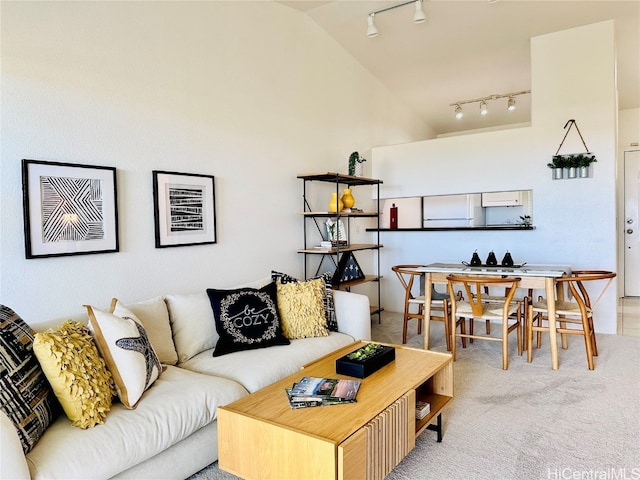 carpeted living room with track lighting and lofted ceiling