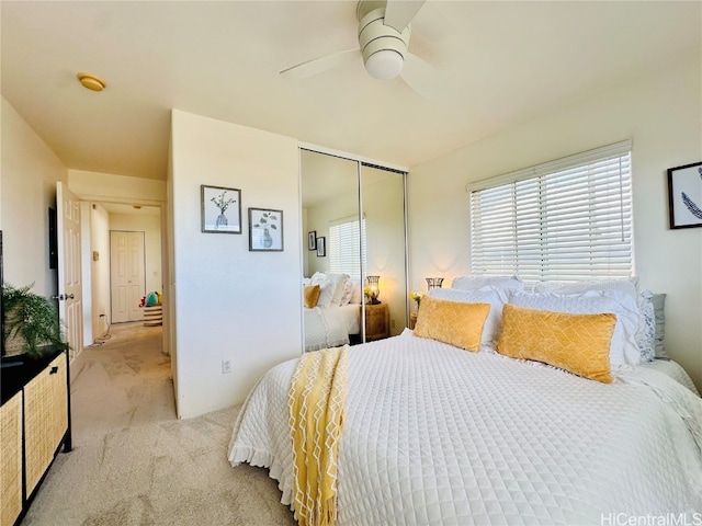 bedroom with light colored carpet, a closet, and ceiling fan