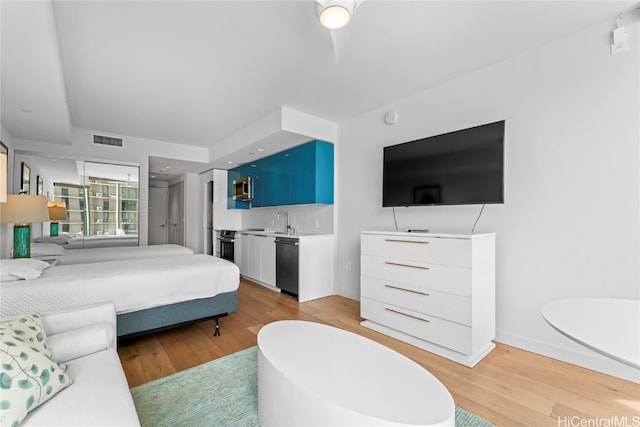 bedroom with light hardwood / wood-style floors and sink