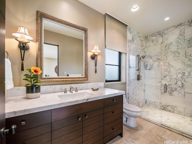 bathroom featuring a shower with door, vanity, and toilet