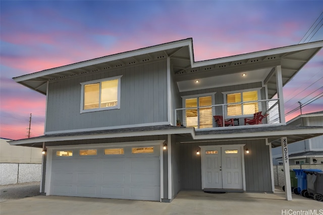 view of front of property featuring a balcony and a garage