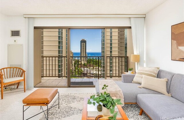 carpeted living room featuring a water view and a textured ceiling