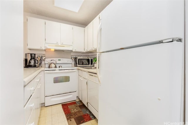 kitchen with under cabinet range hood, white appliances, white cabinets, light countertops, and light floors