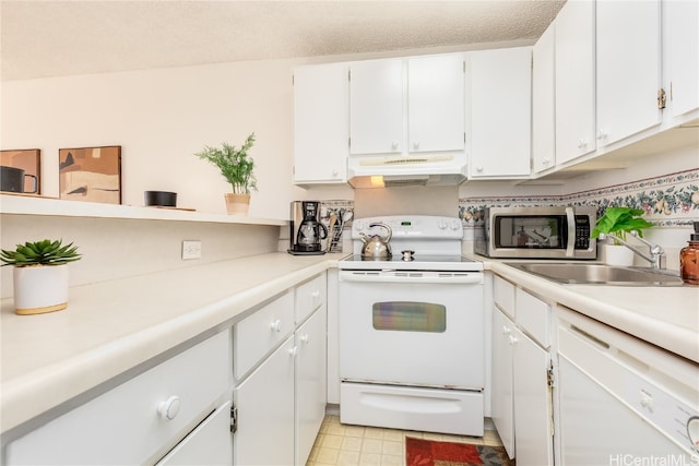 kitchen featuring white appliances, a textured ceiling, sink, and white cabinets