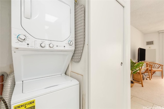 laundry area with stacked washer / dryer, laundry area, visible vents, and carpet