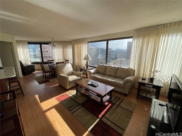 living room featuring a textured ceiling, dark hardwood / wood-style flooring, and a chandelier