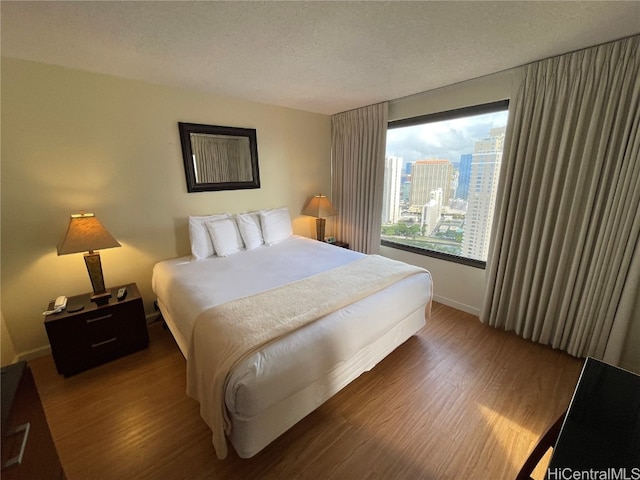 bedroom with a textured ceiling and dark wood-type flooring