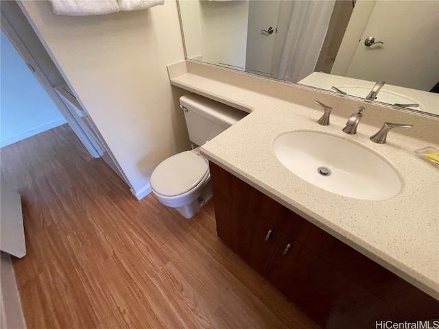 bathroom with vanity, toilet, and wood-type flooring