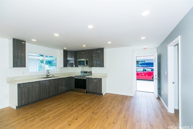 kitchen featuring light hardwood / wood-style floors, appliances with stainless steel finishes, sink, and dark brown cabinets