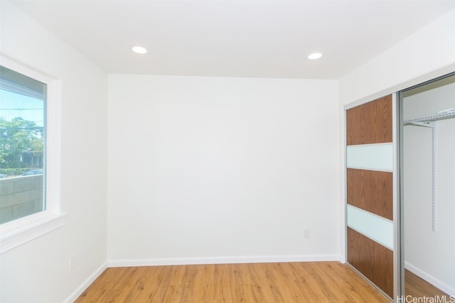 unfurnished bedroom with a closet and light wood-type flooring