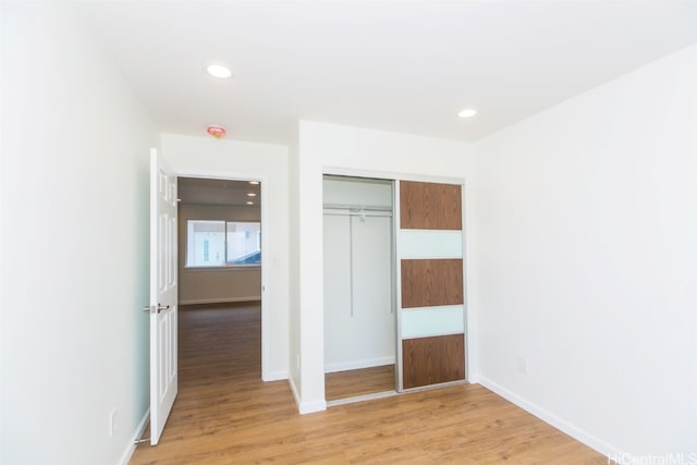 unfurnished bedroom featuring a closet and light wood-type flooring