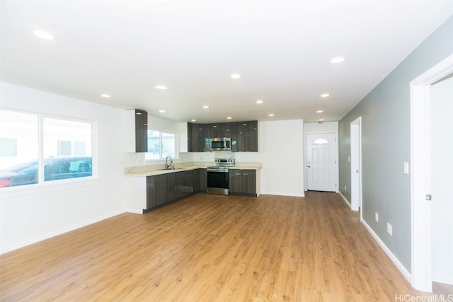 kitchen featuring appliances with stainless steel finishes, light hardwood / wood-style flooring, and sink