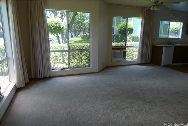 interior space with a wealth of natural light, carpet, cooling unit, and ceiling fan