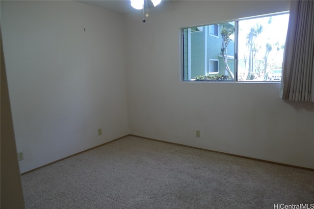 carpeted spare room with ceiling fan