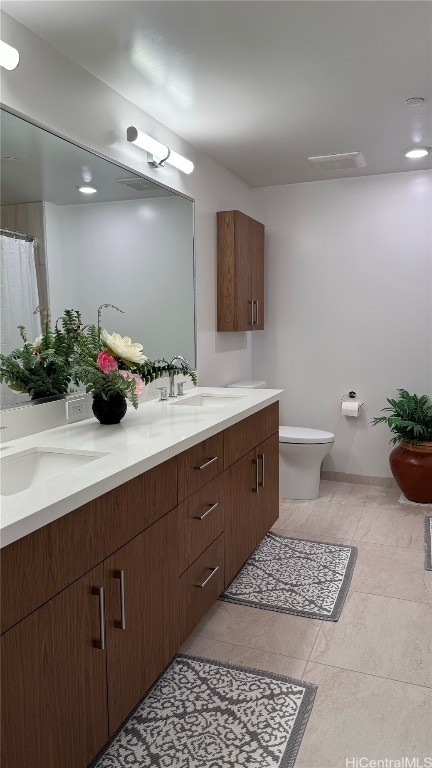 bathroom featuring vanity, toilet, and tile patterned flooring