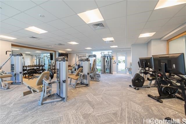 exercise room featuring a drop ceiling and light colored carpet