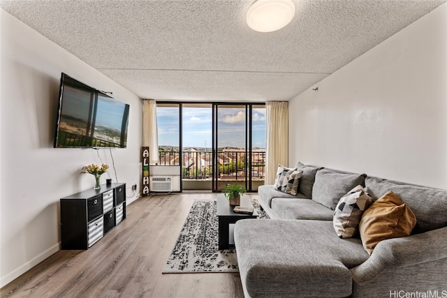 living room with light hardwood / wood-style floors, a textured ceiling, and floor to ceiling windows