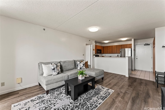 living room featuring dark wood-type flooring and a textured ceiling