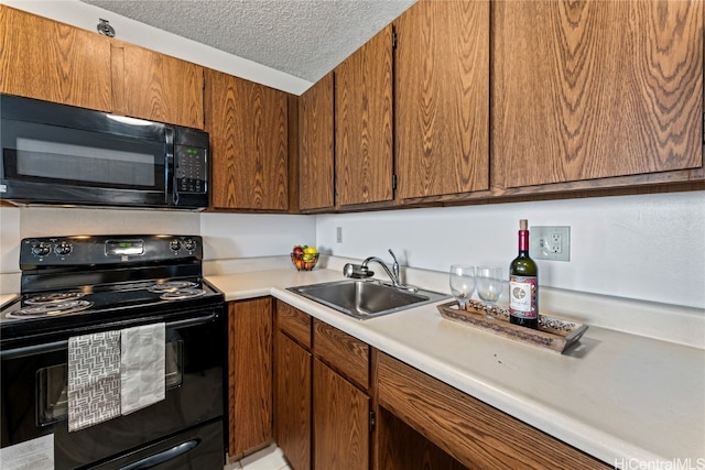 kitchen with a textured ceiling, black appliances, and sink