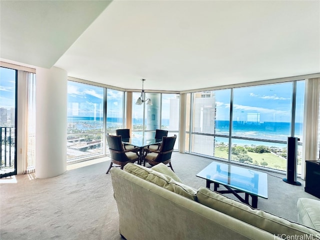 living room with a water view, expansive windows, and carpet floors