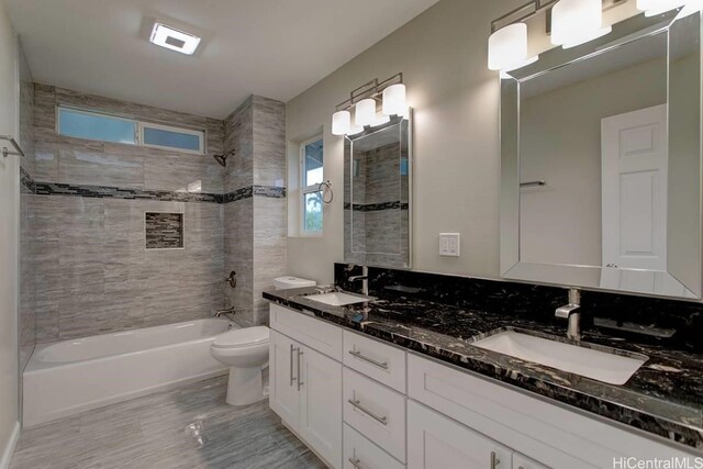 full bathroom with vanity, toilet, and tiled shower / bath combo