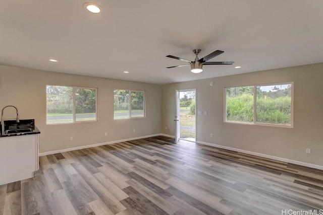 unfurnished living room with light wood-type flooring and ceiling fan