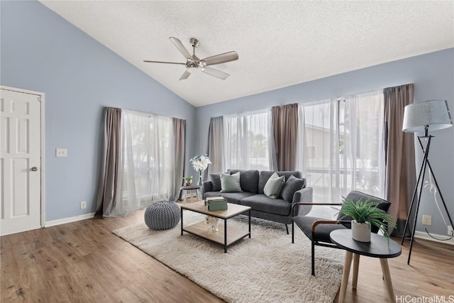 living room with a textured ceiling, ceiling fan, vaulted ceiling, and hardwood / wood-style flooring