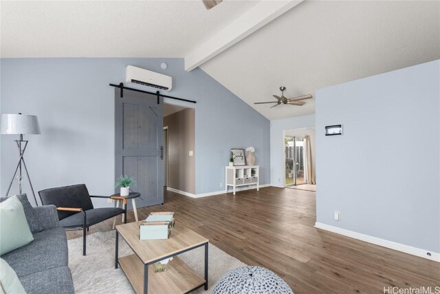 living room with ceiling fan, a barn door, lofted ceiling with beams, a wall mounted AC, and wood-type flooring