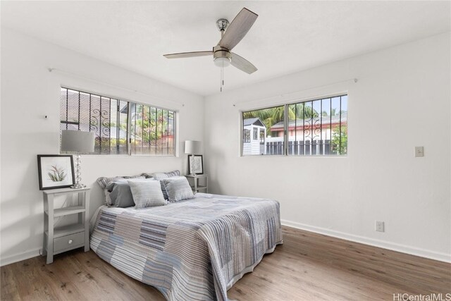 bedroom featuring multiple windows, ceiling fan, and light hardwood / wood-style floors