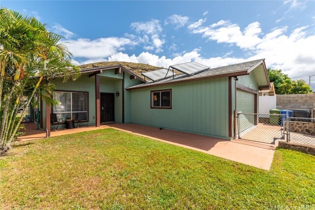 rear view of house with a yard and a patio