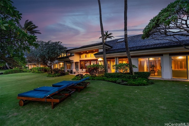 back house at dusk with a yard