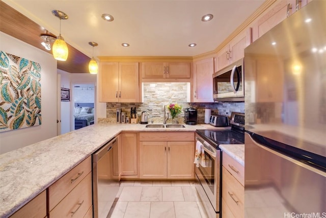 kitchen featuring light brown cabinetry, stainless steel appliances, hanging light fixtures, and sink