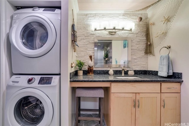 clothes washing area featuring stacked washer / dryer and sink