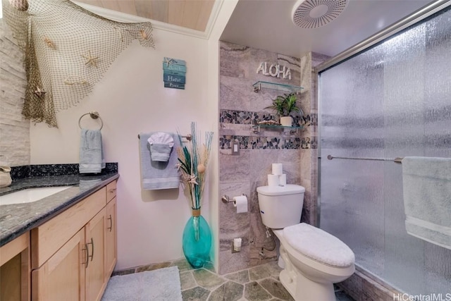 bathroom featuring toilet, vanity, crown molding, and a shower with shower door