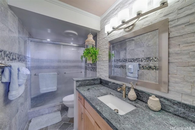 bathroom featuring toilet, a shower with shower door, tile walls, and ornamental molding