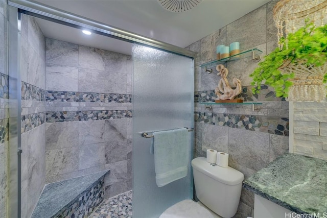 bathroom featuring toilet, an enclosed shower, and tile walls