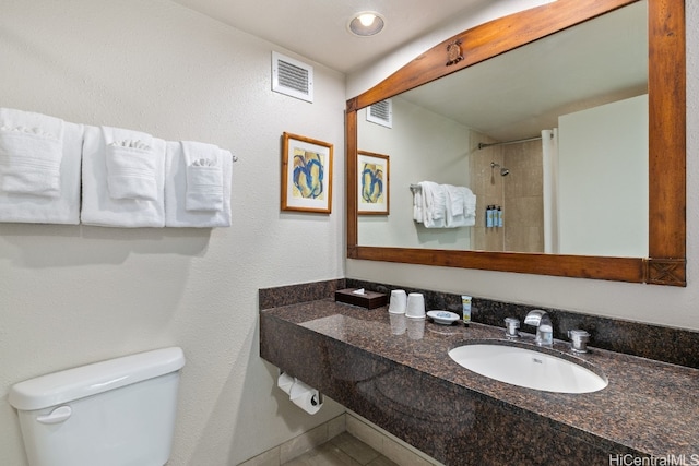 bathroom featuring toilet, a shower, and sink