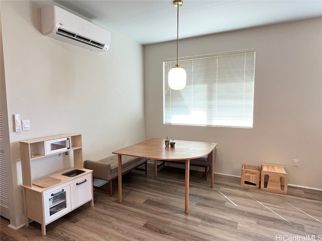 dining room with a wall unit AC and wood-type flooring