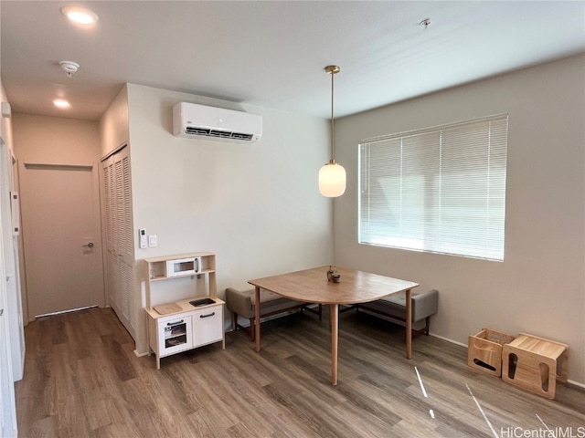 dining space with hardwood / wood-style flooring and a wall mounted AC