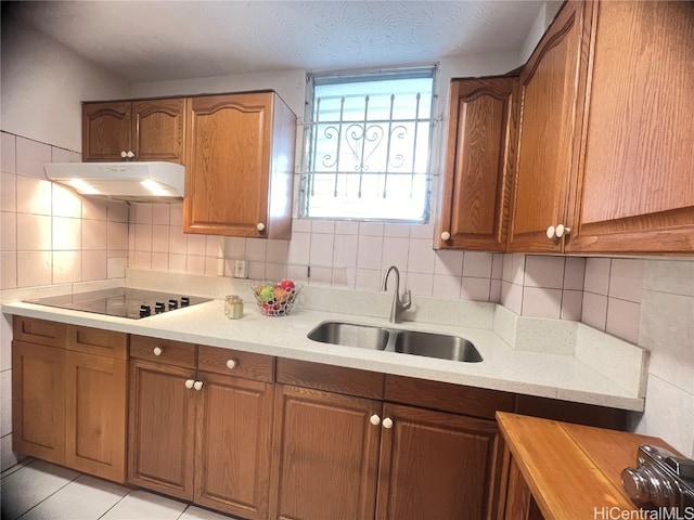 kitchen with tasteful backsplash, a textured ceiling, sink, and light tile patterned flooring