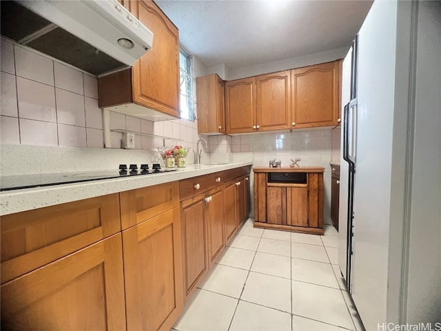 kitchen featuring sink, backsplash, extractor fan, and light tile patterned floors