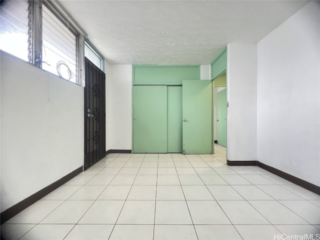 unfurnished bedroom featuring a textured ceiling and light tile patterned flooring