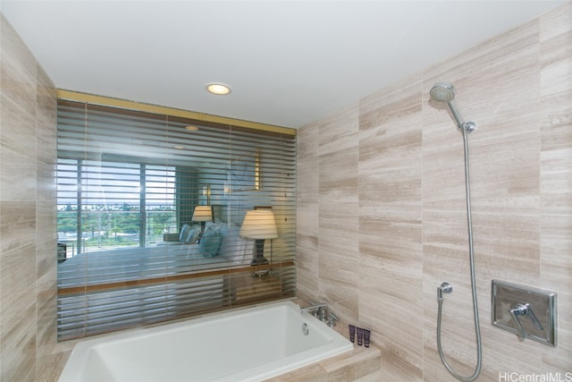 bathroom with tile walls and shower with separate bathtub