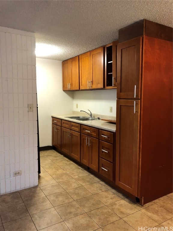 kitchen featuring light tile patterned flooring, a textured ceiling, and sink