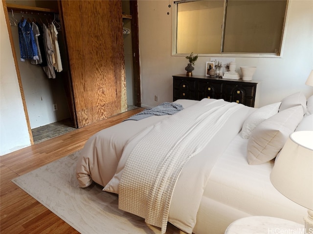 bedroom with light hardwood / wood-style flooring and a closet