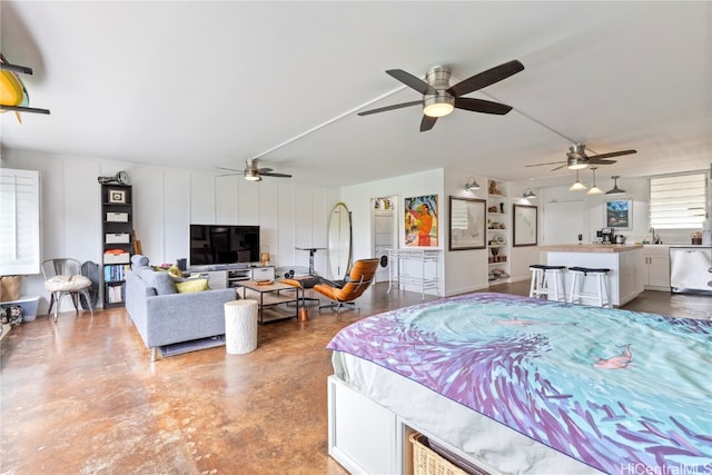 bedroom with concrete floors, sink, and ceiling fan