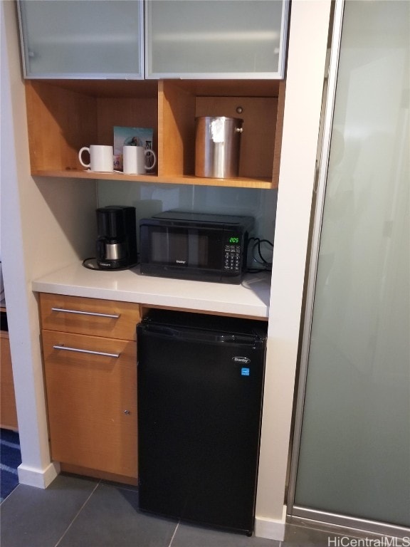 kitchen with black appliances and dark tile patterned floors